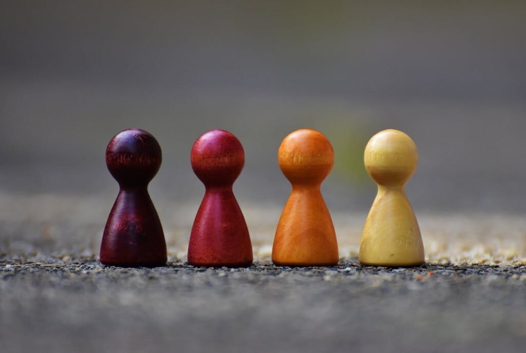 pexels-photo-209728 Close-up of four colorful wooden pawn pieces arranged in a row.